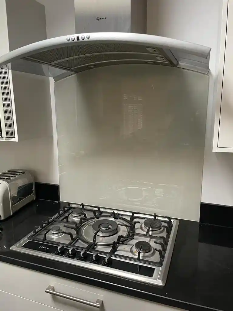 Glass splashback behind gas hob and extractor by Bucks Glazing